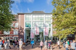 Altonaer Museum - Hamburg - Außenansicht: Das Museumsgebäude mit wehenden Fahnen und Passanten am Platz der Republik