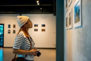 Archäologisches Museum Hamburg - Ausstellung: Besucherin mit Kamera betrachtet Fotografien in der Sonderausstellung Lost Places