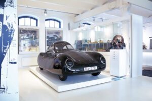 Automuseum PROTOTYP - Hamburg - Porsche Typ 64: Der schwarze Ur-Porsche von 1939 auf einem weißen Podest