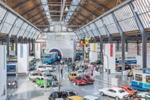 Deutsches Museum Verkehrszentrum - München - Ausstellung Straßenverkehr mit einer Straßeninszenierung aus verschiedenen Epochen, historischen Bahnen und einem gelben Hubschrauber in Halle I