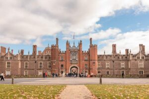 Hampton Court Palace - London - Great Gatehouse: Der imposante Haupteingang aus rotem Backstein mit typischen Tudor-Schornsteinen und Besuchern