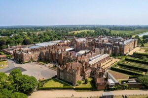 Hampton Court Palace - London - Luftaufnahme: Die gesamte Schlossanlage aus der Vogelperspektive mit dem deutlichen Kontrast zwischen Tudor-Backsteinbauten und barocker Architektur.