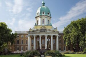 Imperial War Museum London - Außenansicht: Das monumentale Museumsgebäude mit der markanten Kuppel und dem beeindruckenden 15-Zoll-Geschütz davor
