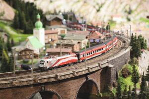 Miniatur Wunderland - München - Ausstellung Österreich: Ein Zug überquert eine Brücke in einer detaillierten Alpenlandschaft