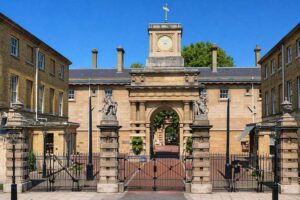 The Royal Mews - London - Außenansicht: Der historische Eingang zum Royal Mews in London mit Torbogen, Turmuhr und zwei Löwenstatuen