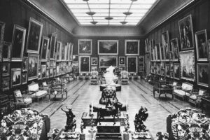 The Wallace Collection - London - Große Galerie ca. 1890: Eine historische Schwarz-Weiß-Fotografie der dicht behängten Kunstgalerie mit zahlreichen Gemälden und antiken Möbeln im 19. Jahrhundert