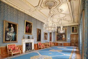 Windsor Castle - London - Queen's Gallery: Ein vornehmer Saal verzierten Wänden, prunkvoller Decke und zahlreichen Ölgemälden in Goldrahmen