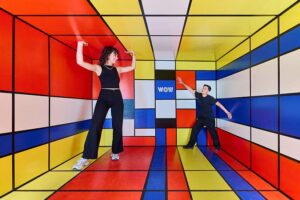 WOW Museum - München - Optische Täuschung: Zwei Personen in einem optisch verzerrten Raum im farbenfrohen Mondrian-Design